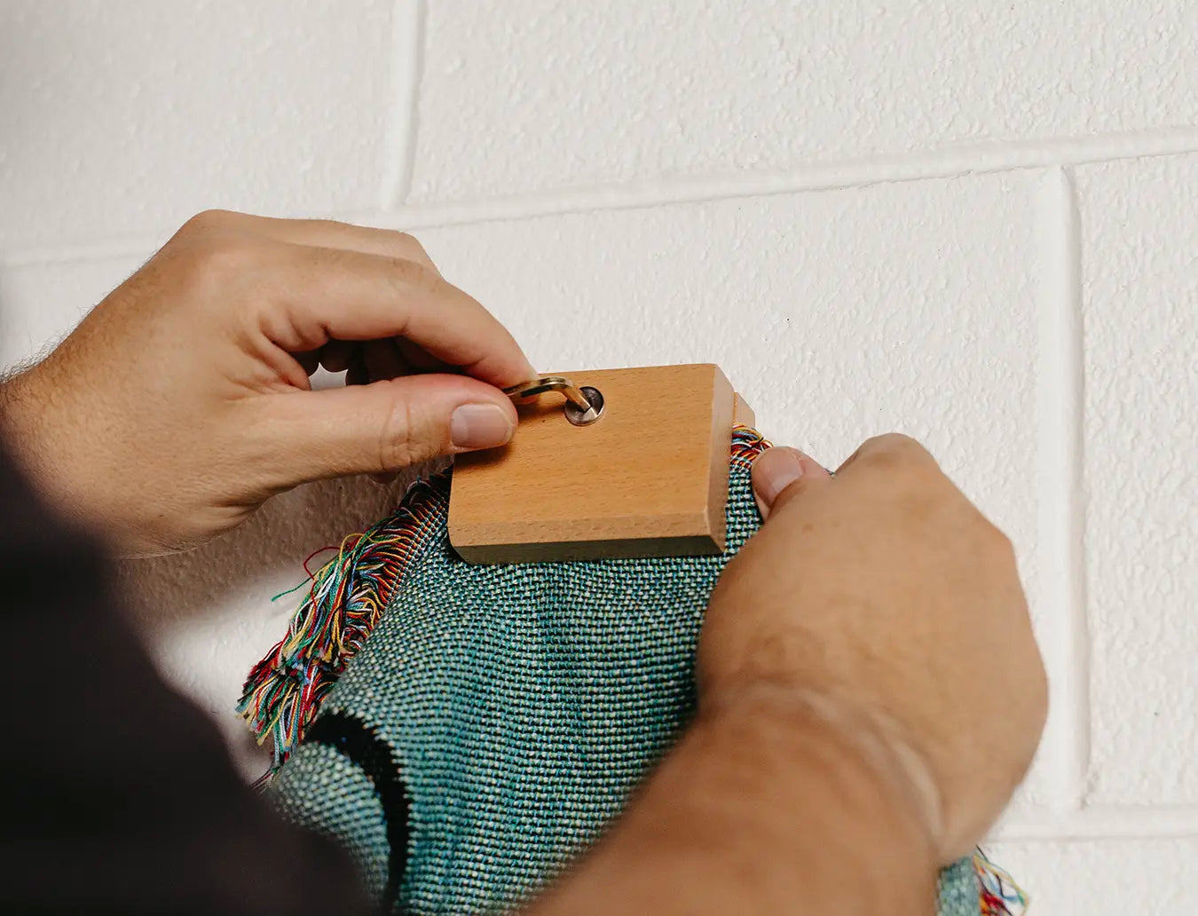 Person inserting blanket fabric into the blanket hanger clips