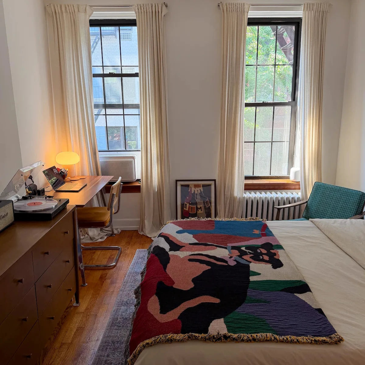 colorful bed blanket featuring design of dog in a New York City apartment bedroom