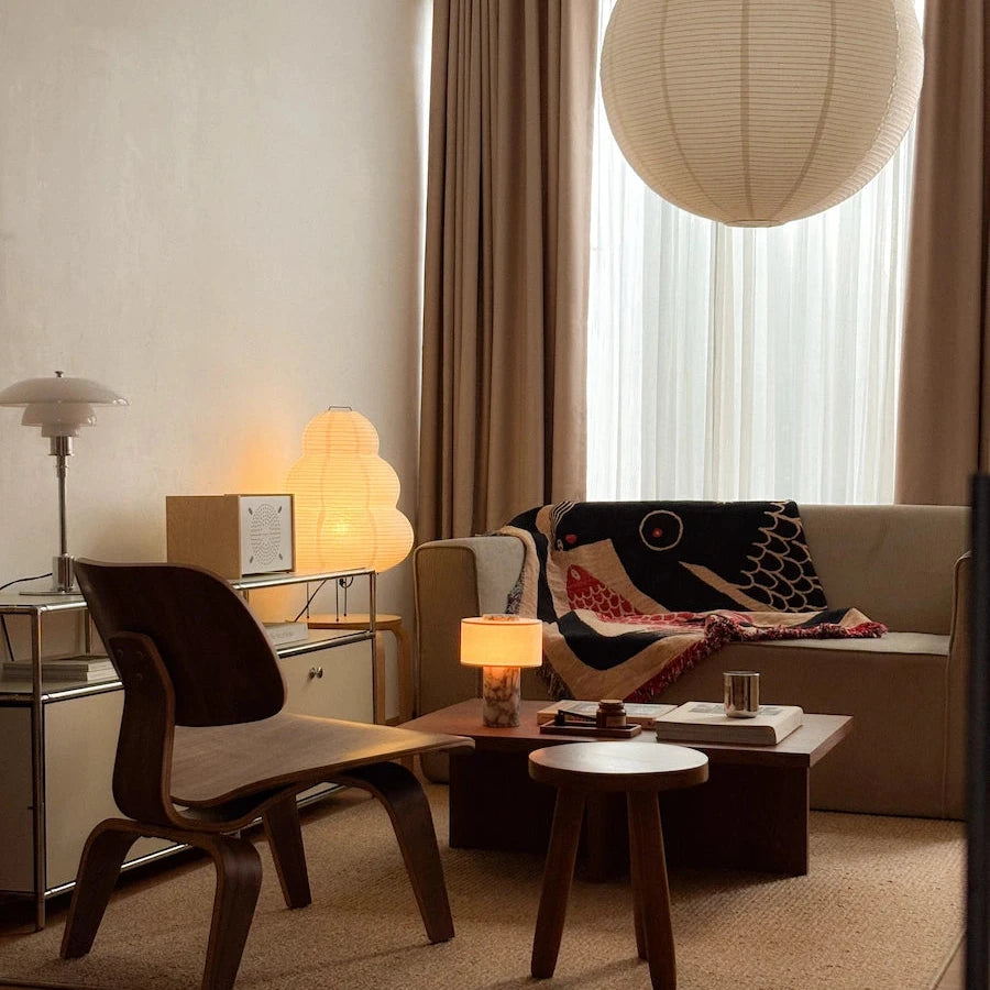 Modern living room with a red and black blanket for couch, sofa, chair, and decorative items.