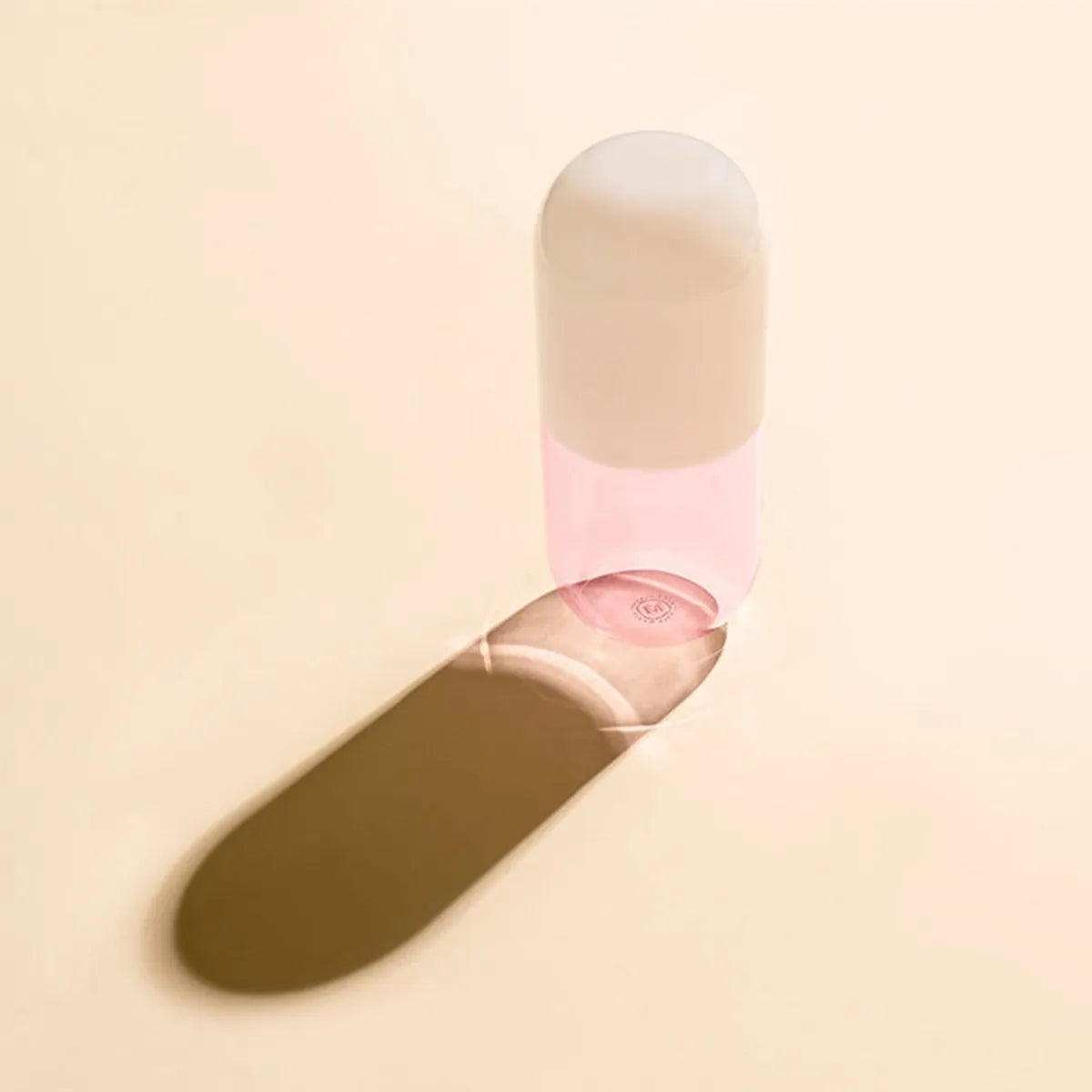 Pink glass carafe with a white lid on a beige background