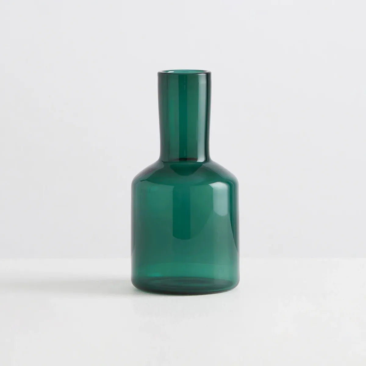 Green glass carafe on a white background