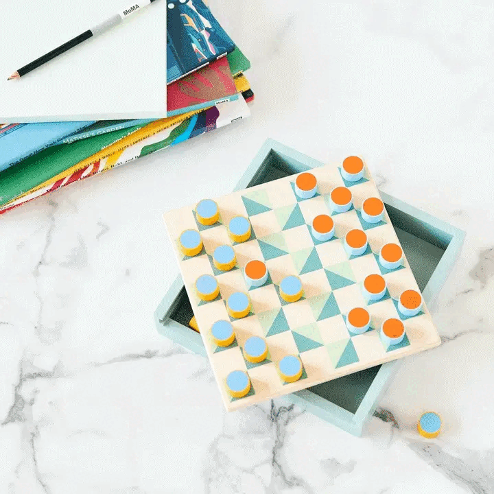 Looping video of a wooden board game with colorful cylindrical pieces on a marble stone table