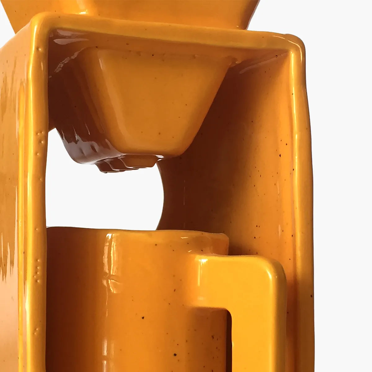 Yellow coffee maker pouring coffee into a yellow cup on a gray background