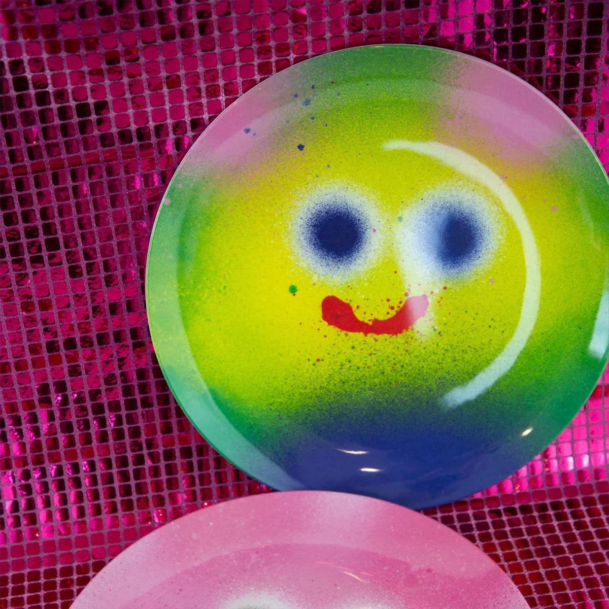 Colorful smiley face plate on a pink textured background