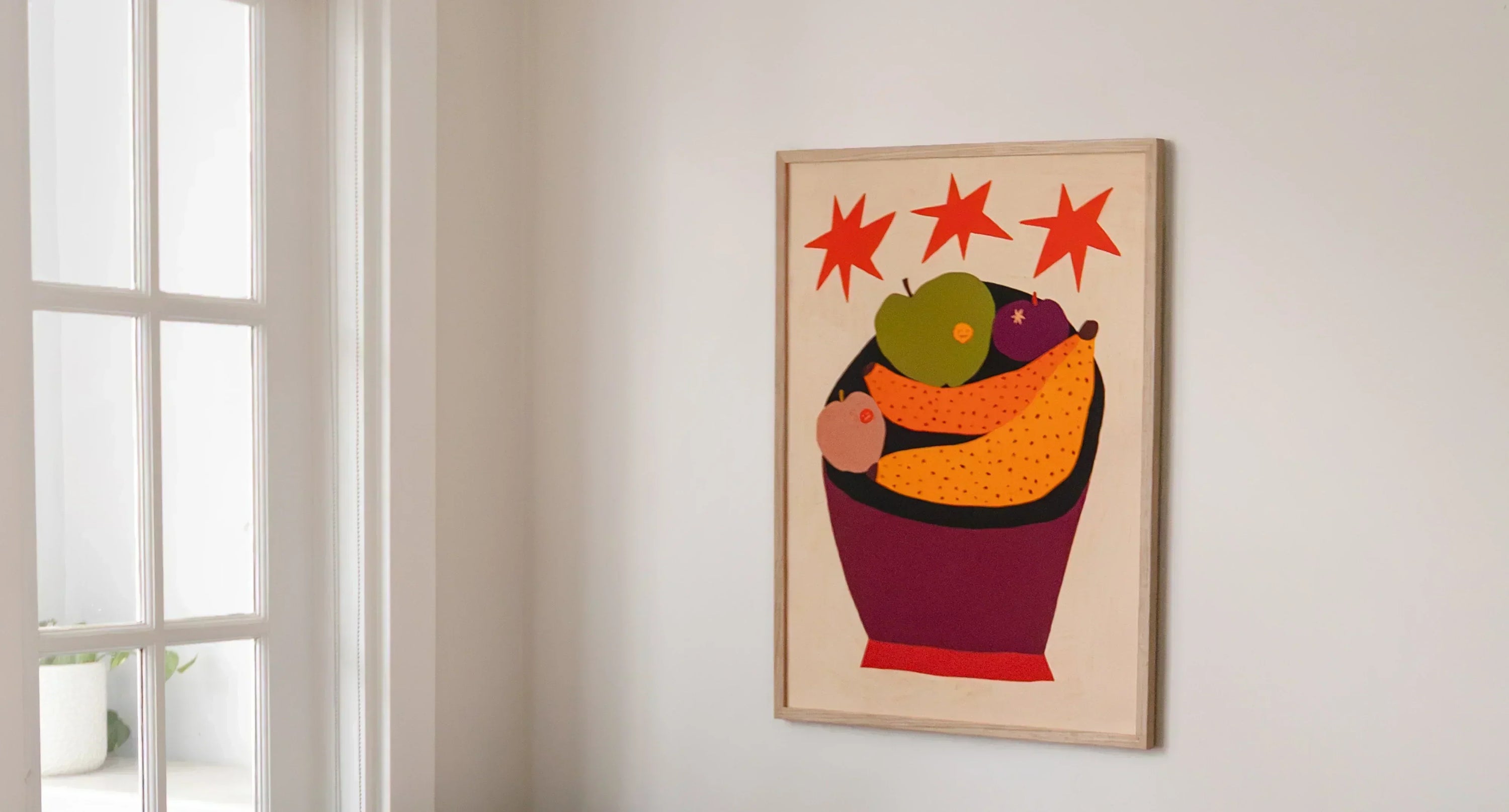 Art print in frame on a wall showing an artwork of fruit in a bowl