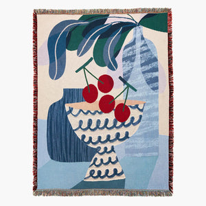 Bed throw blanket with blue and red still life of cherries in a bowl