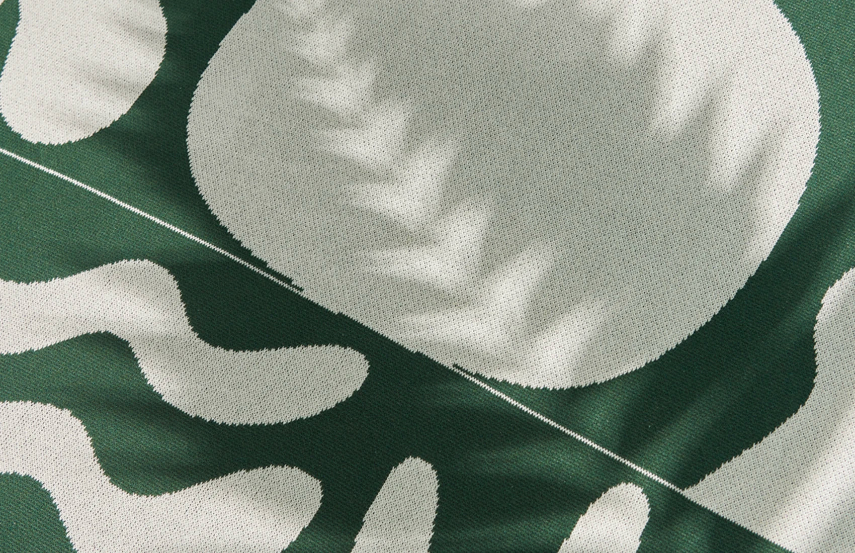 Close-up of a green fabric with white leaf pattern