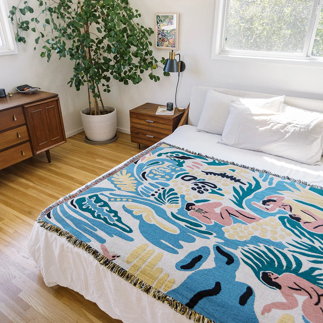 Bedroom with a colorful tapestry on the bed featuring abstract designs.