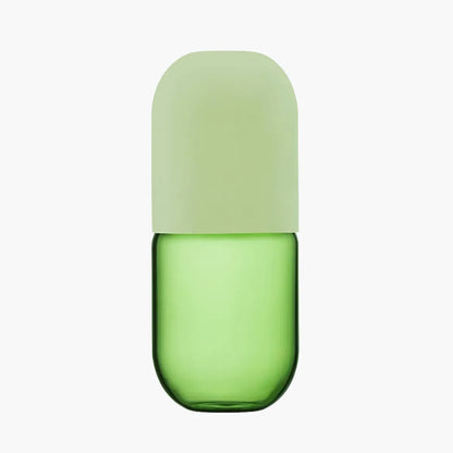 Green glass carafe with a light green lid on a white background