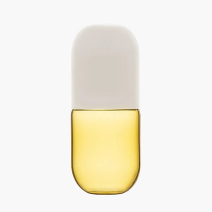 Yellow glass carafe with a white lid on a white background