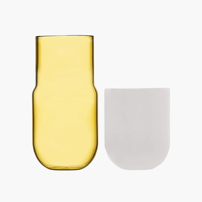 Yellow glass carafe and white cup on a white background