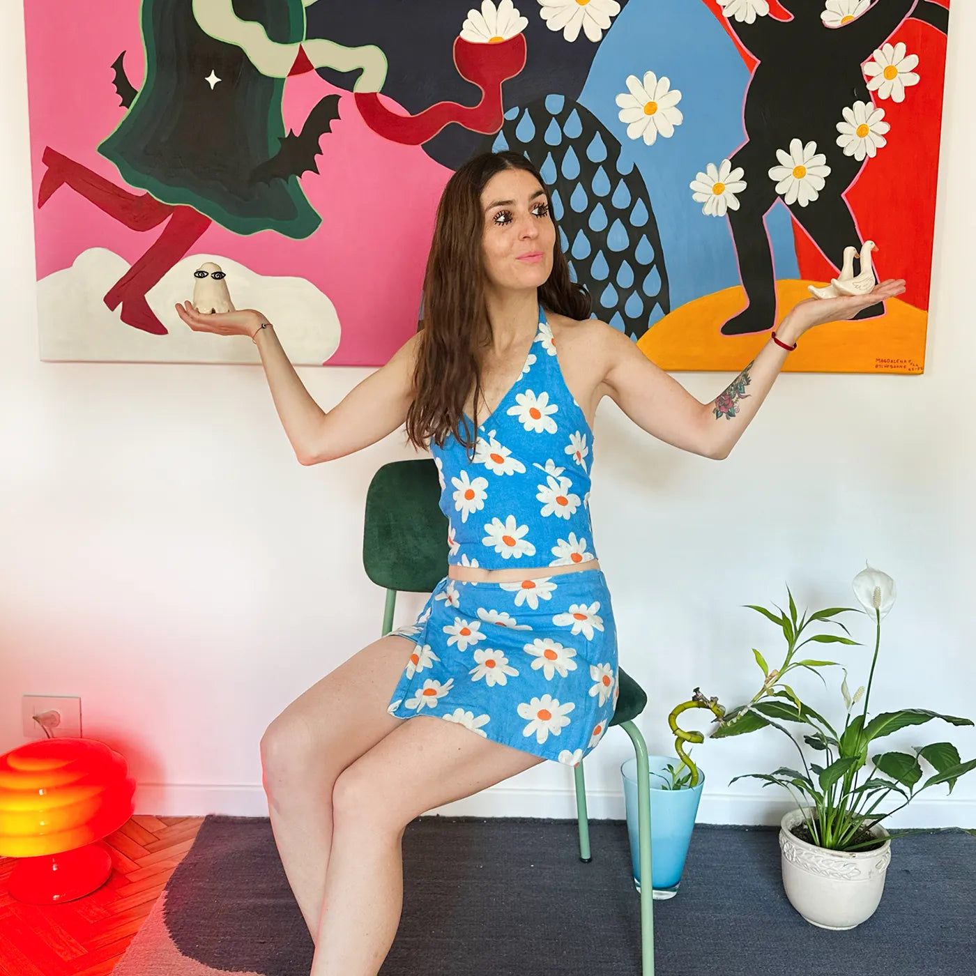 Portrait of Argentinian artist Magdalena Etchebarne (Magucha) with a large wall art piece behind her.