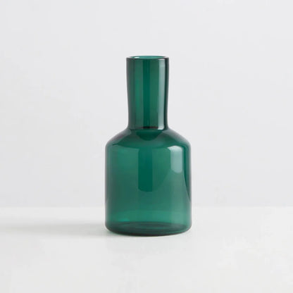 Green glass carafe on a white background