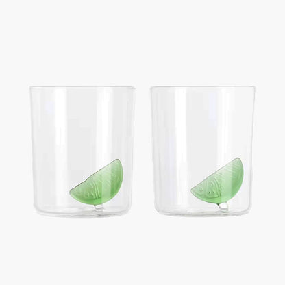Two clear glasses with green lime slices on a white background