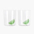 Two clear glasses with green lime slices on a white background