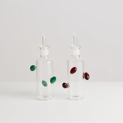 Two glass bottles with droppers and colorful beads on a white background