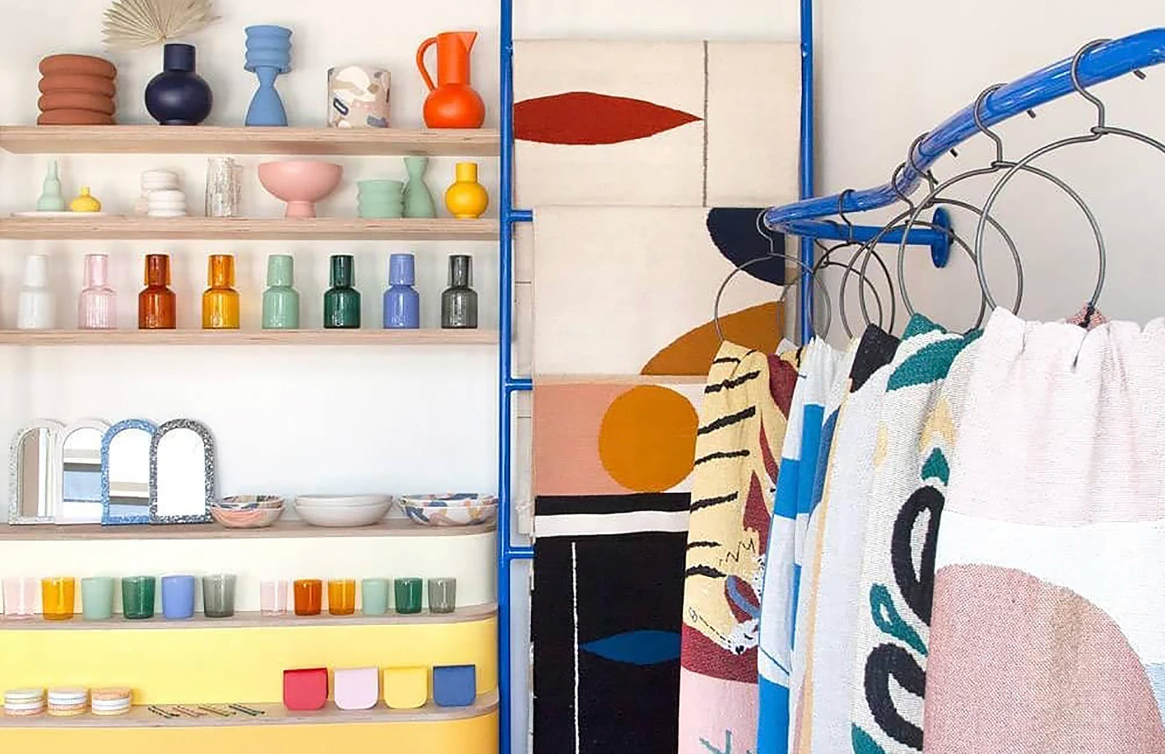 Shelves with colorful decorative items and a clothing rack with patterned clothes.