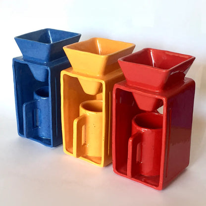 Three colorful coffee makers in red, yellow, and blue on a wooden surface.