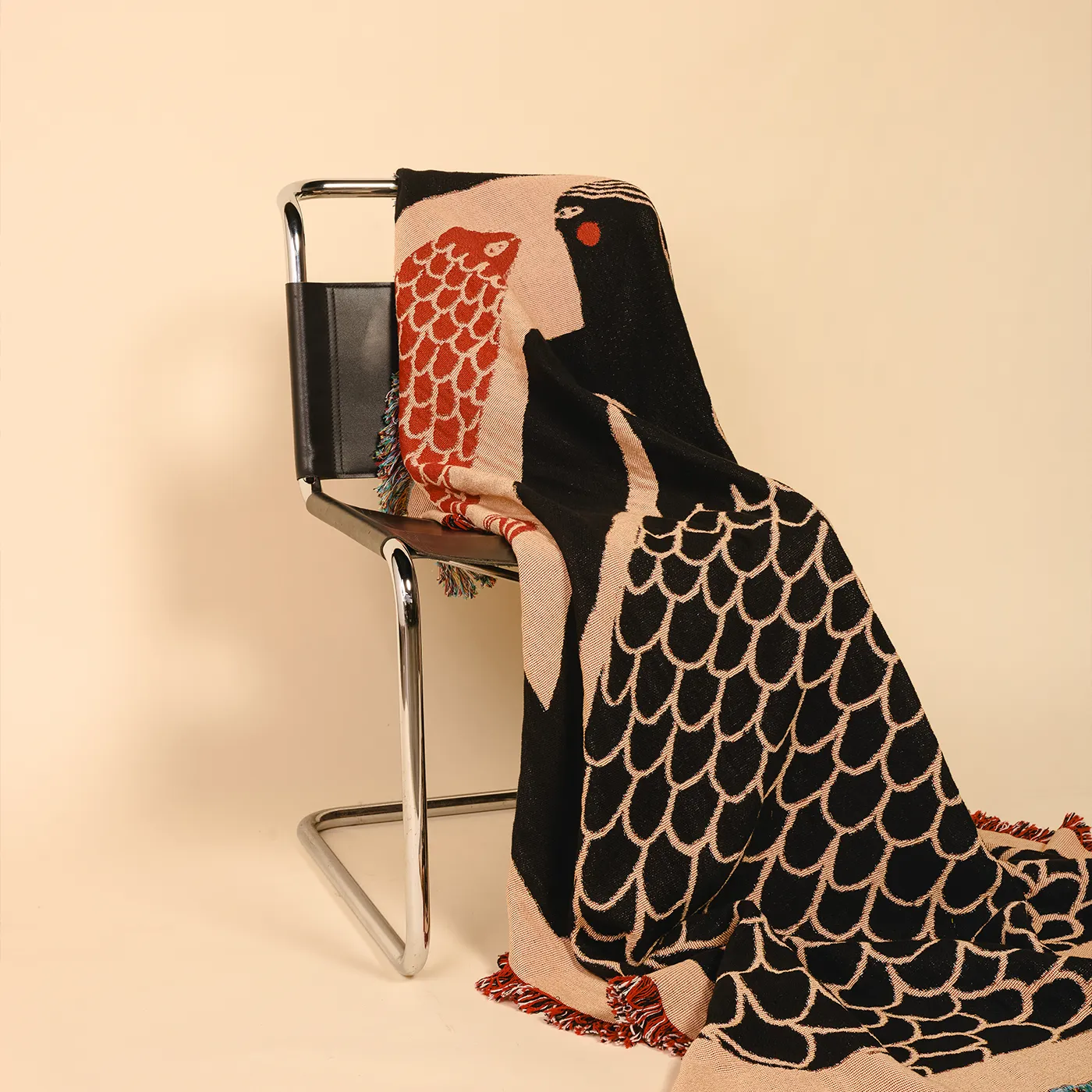 Decorative blanket with mermaid design draped over a chair on a beige background