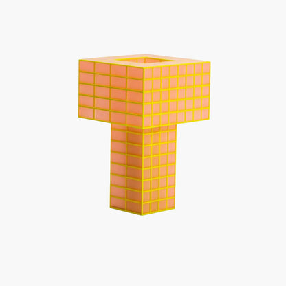 A T-shaped Ridezign Tesser 5:8 table lamp made of glowing square grid panels in orange and yellow, set against a plain white background.