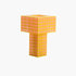 A T-shaped Ridezign Tesser 5:8 table lamp made of glowing square grid panels in orange and yellow, set against a plain white background.