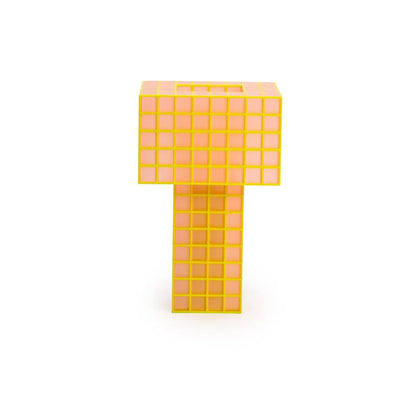 A translucent orange Ridezign Tesser 5:8 Lamp shaped like the letter T, featuring a grid pattern on a solid white background.