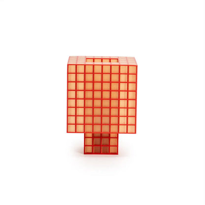 A translucent orange-red Ridezign Tesser 8:3 Lamp with a grid pattern, standing upright on a white background.