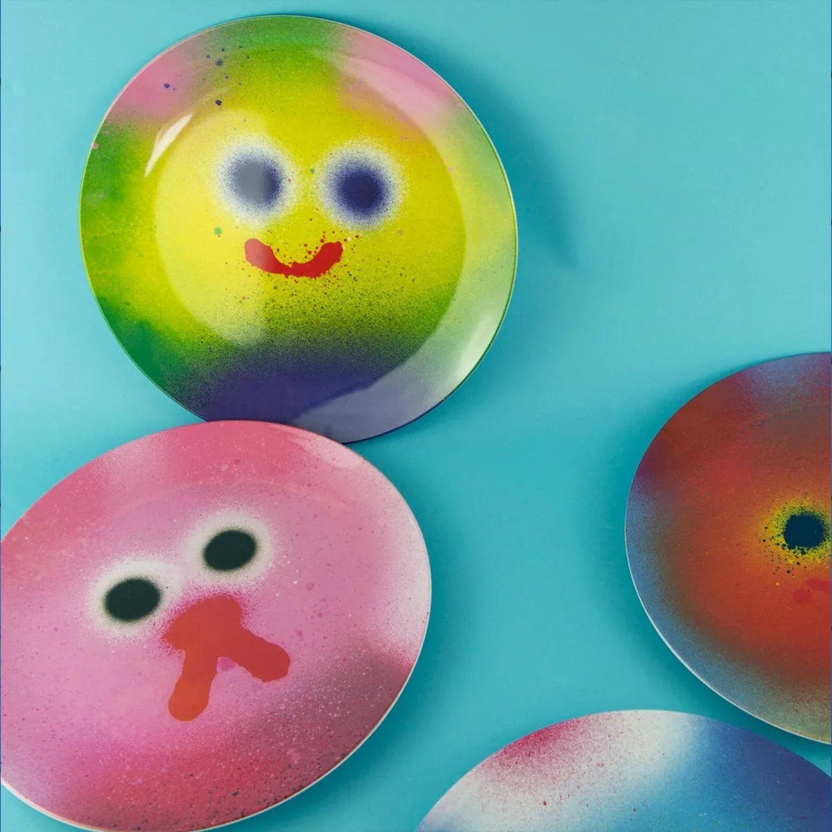 Colorful round plates with face-like designs on a blue background