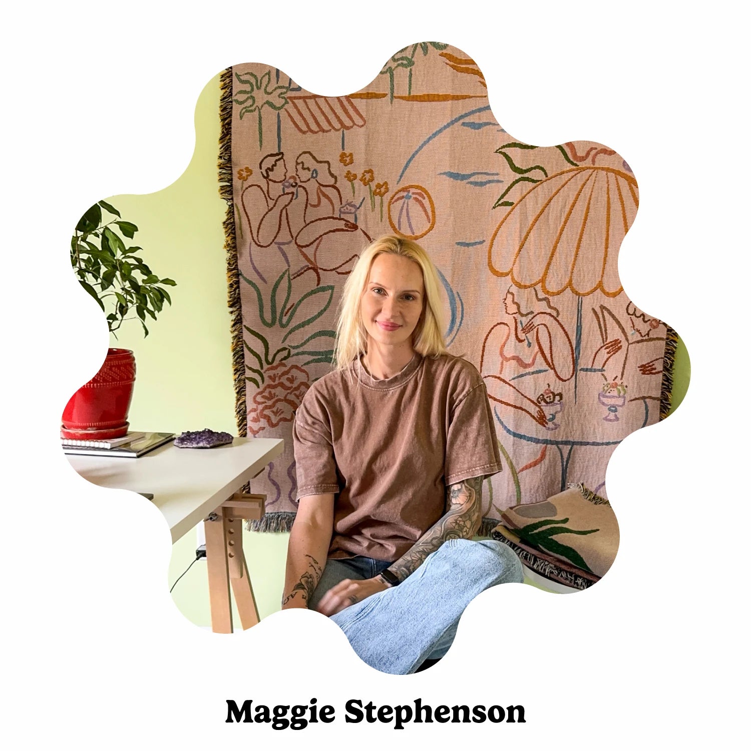 Person sitting in front of a decorative wall hanging with artistic designs, branded &