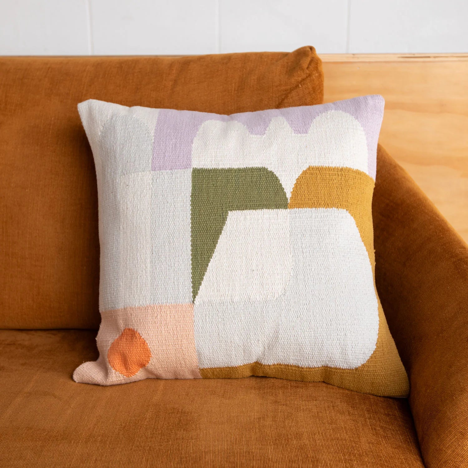 Decorative pillow with geometric pattern on a brown couch