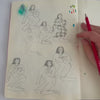 Argentinian artist Yamila Yjilioff painting an art print design in her sketchbook.